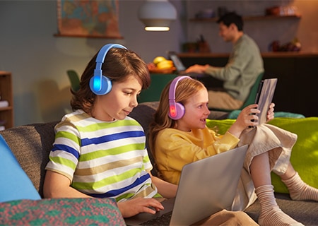 Barn som använder sina Philips on-ear-hörlurar med funktionen för färgglada tända paneler på