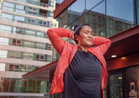  Kvinna som anvander Philips A5508 trådlösa hörlurar utomhus