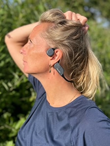 Kvinna som bär Philips bone conduction-hörlurar med Bluetooth