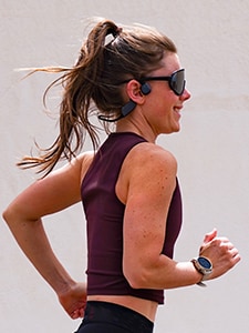 Kvinna som springer med bone conduction-hörlurar