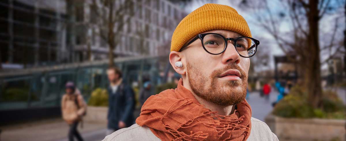 Närbildsfoto av en man som bär äkta trådlösa hörlurar