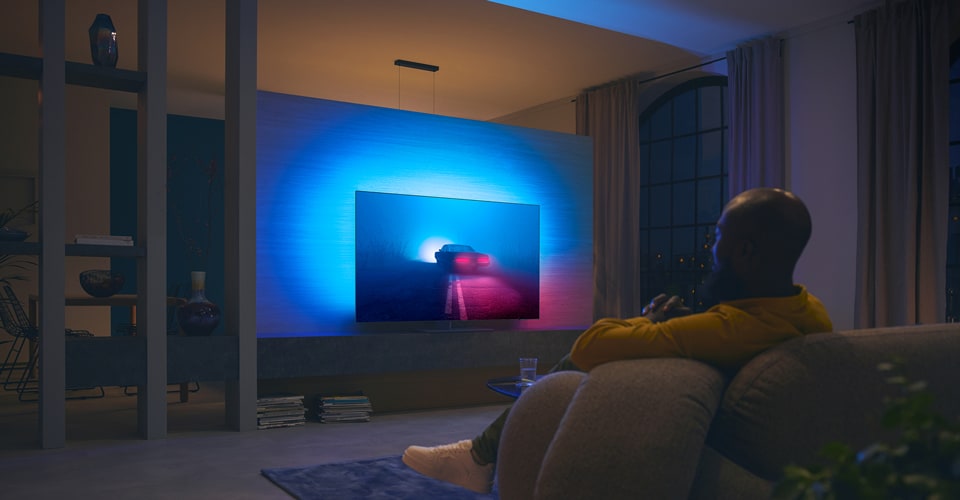 Ett par tittar på film på Ambilight-TV