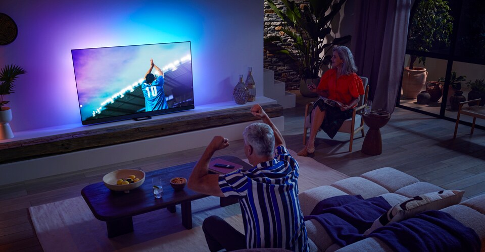 Familj tittar på match med OLED-TV