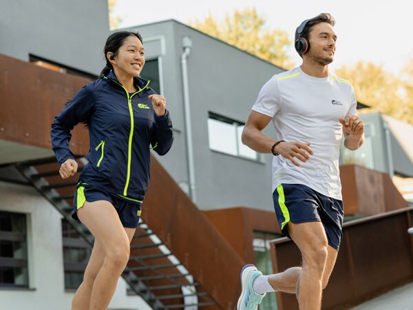 Två deltagare i loppet springer med sina Philips-hörlurar.