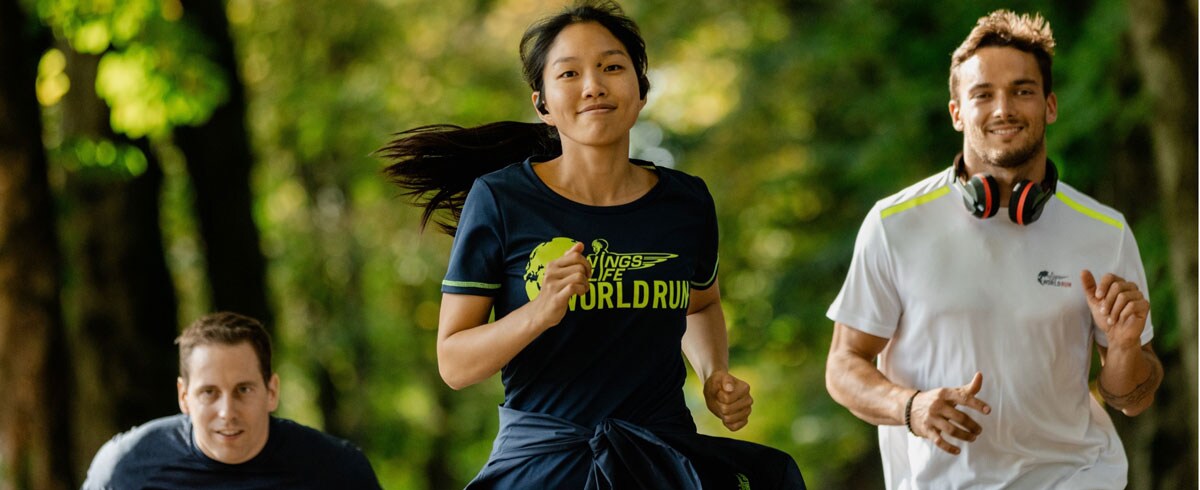 Tre Wings for Life World Run-deltagare springer och bär Philips sporthörlurar.