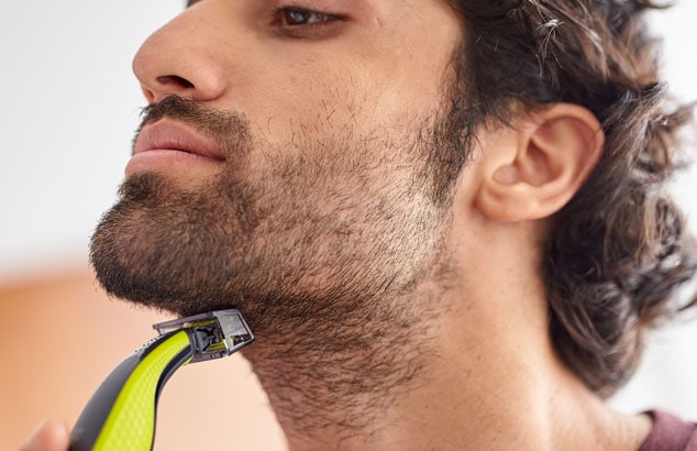 Bild av en man som använder Philips OneBlade för att trimma nacklinjen.