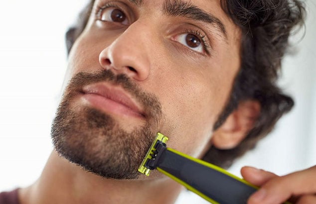 Ansiktet av en man som rakar den yttre linjen på sitt bockskägg med en Philips OneBlade.