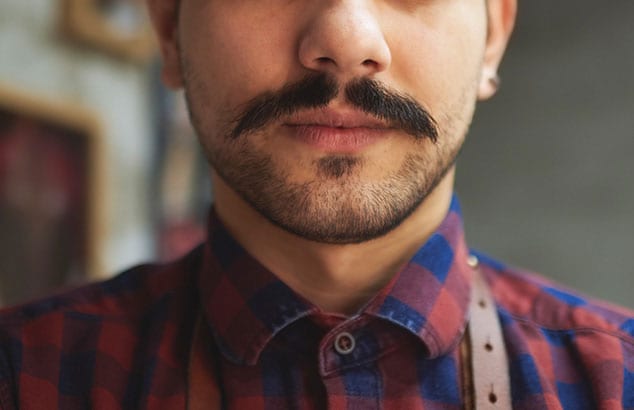 Närbild av en haka på en man som har mustasch och kort getskägg.