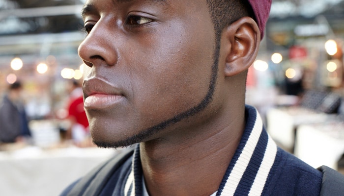 Bild tagen från sidan av en mans ansikte med perfekt trimmat hakskägg.