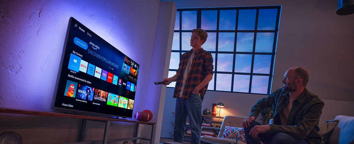 En man som väljer en app på Philips Smart TV